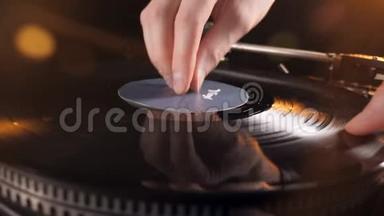 一个人把一个黑盘放在一个乙烯基播放器上，并按下一个按钮。